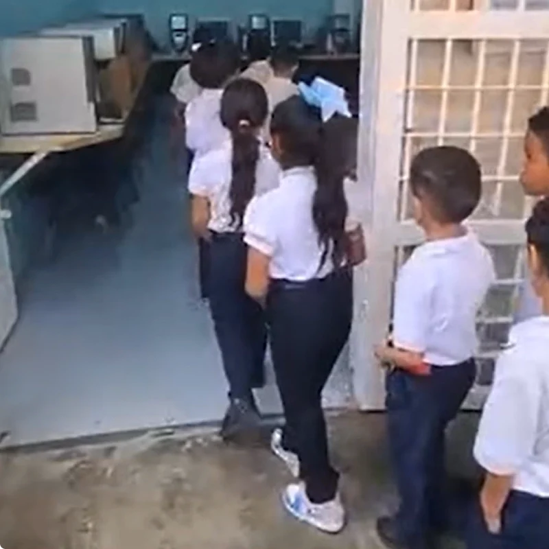 Estudiantes en fila para entrar en salon de clase de colegio Fe y Alegria